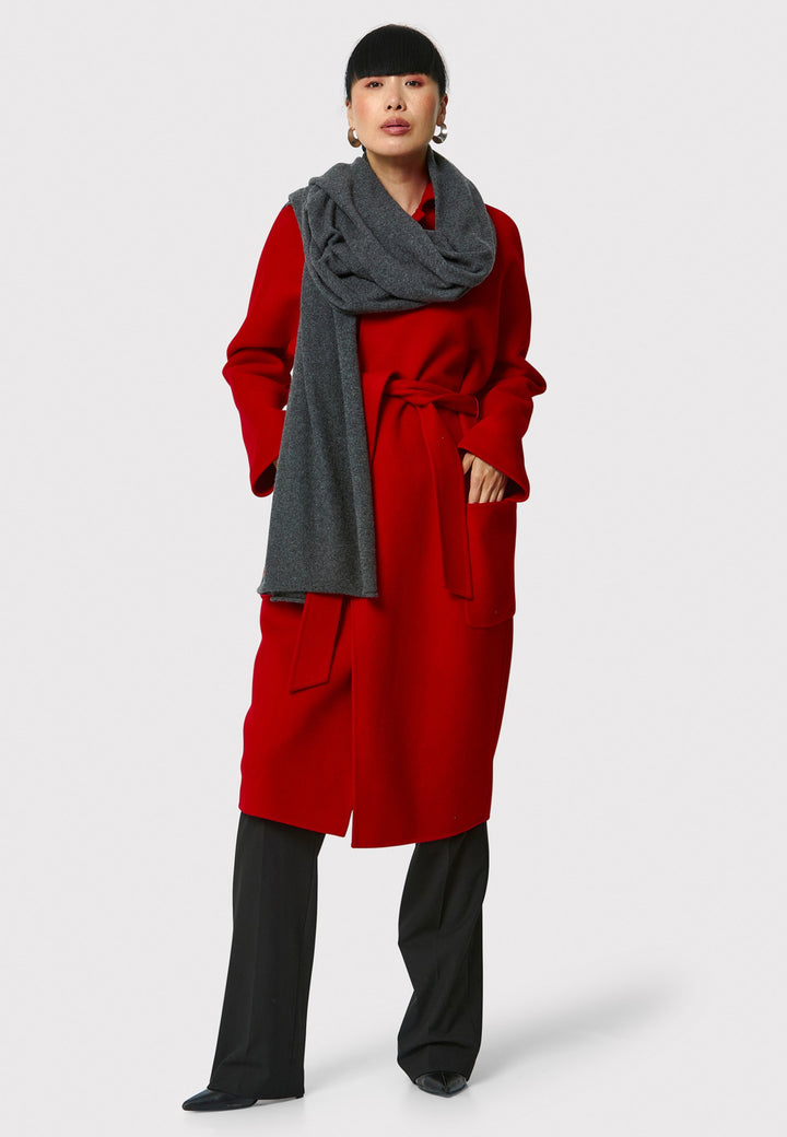 Introducing the Zola Cherry Red Cashmere Coat, a luxurious blend of cashmere and wool. This unlined coat features an oversized silhouette with patch pockets and a detachable belt. The dropped sleeves and tailor pick stitch finish add a touch of sophistication. Complete with a traditional collar and revere, it's a statement piece for your winter wardrobe.