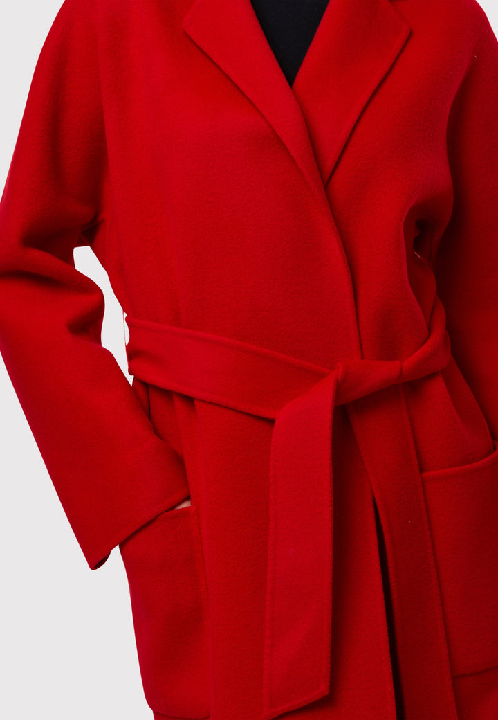 Introducing the Zola Cherry Red Cashmere Coat, a luxurious blend of cashmere and wool. This unlined coat features an oversized silhouette with patch pockets and a detachable belt. The dropped sleeves and tailor pick stitch finish add a touch of sophistication. Complete with a traditional collar and revere, it's a statement piece for your winter wardrobe.
