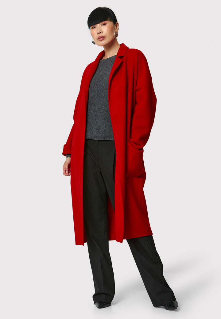 Introducing the Zola Cherry Red Cashmere Coat, a luxurious blend of cashmere and wool. This unlined coat features an oversized silhouette with patch pockets and a detachable belt. The dropped sleeves and tailor pick stitch finish add a touch of sophistication. Complete with a traditional collar and revere, it's a statement piece for your winter wardrobe.