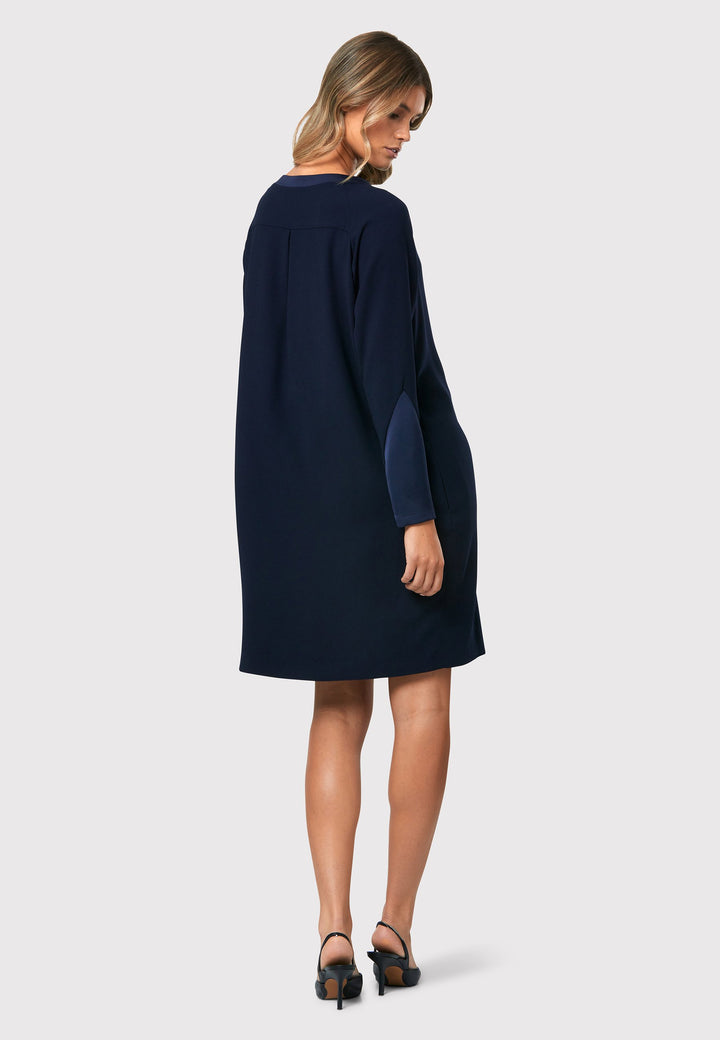  Adelaide Midnight Navy Dress, a knee-length ensemble that exudes timeless elegance. This chic dress features a satin cuff detail with an elegant point, adding a sophisticated touch to the design