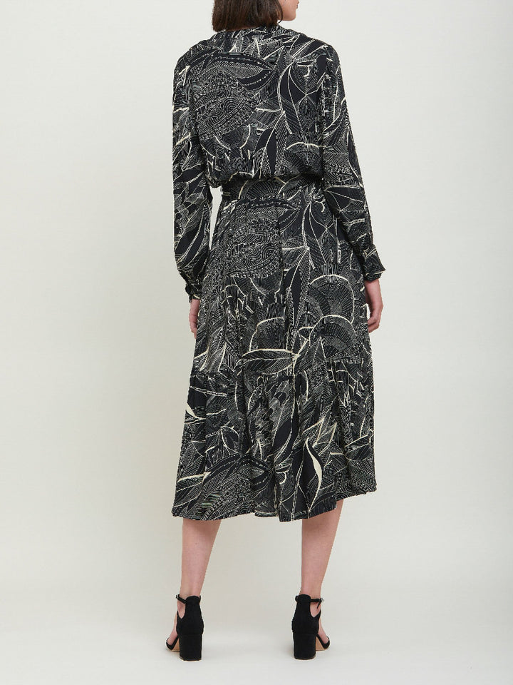 Beverly, an everyday dress. Crafted in a fluid, cream on black, botanical print viscose. A simple style with a V-neck button down bodice, handy pockets, elasticated waist & matching belt. Dress offers voluminous sleeves & a centre front slit on a fluid tiered skirt which falls to the mid-calf. 