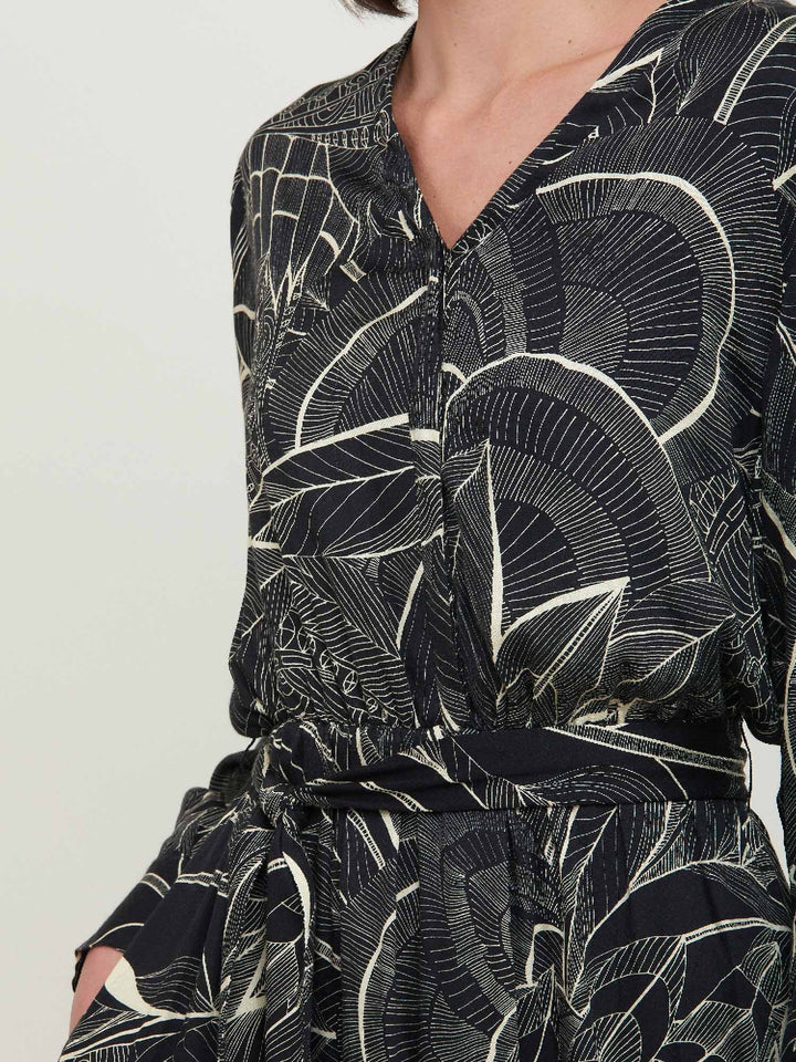 Beverly, an everyday dress. Crafted in a fluid, cream on black, botanical print viscose. A simple style with a V-neck button down bodice, handy pockets, elasticated waist & matching belt. Dress offers voluminous sleeves & a centre front slit on a fluid tiered skirt which falls to the mid-calf. 