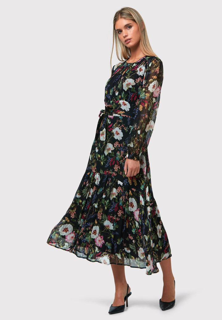 Bev Floral Noir Print Dress, a sophisticated choice that adds an elegant touch to your everyday wardrobe, now and in the future. This exquisite dress features a sweeping midi-length silhouette, designed with a blend of simplicity and feminine flair. The Jewel neckline is delicately enhanced with gentle gathers, while the softly flared skirt offers a flattering fit. 