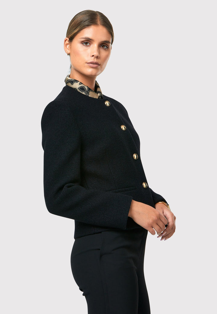 Introducing the Cassandra Black Jacket, a sleek and fitted piece crafted from a textured black boucle fabric. With its softly tailored silhouette, this jacket exudes modern elegance. The gold detail buttons add a touch of sophistication and elevate the overall aesthetic. Pair it effortlessly with the classic Jill pant for a timeless ensemble. The contemporary silhouette of the Cassandra Black Jacket is destined to become your go-to workwear icon for the season.