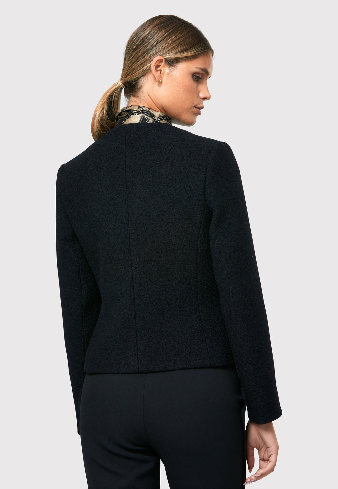 Introducing the Cassandra Black Jacket, a sleek and fitted piece crafted from a textured black boucle fabric. With its softly tailored silhouette, this jacket exudes modern elegance. The gold detail buttons add a touch of sophistication and elevate the overall aesthetic. Pair it effortlessly with the classic Jill pant for a timeless ensemble. The contemporary silhouette of the Cassandra Black Jacket is destined to become your go-to workwear icon for the season.