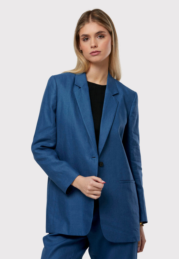 Cassie, the investment-worthy borage blue linen blazer. The epitome of summer sophistication. Minimalist styling accentuated by a single button fastening and an oversized, slightly boxy silhouette. Pair it effortlessly with a simple tee and the coordinating Vanessa pant, finished with trainers for a chic and contemporary ensemble.