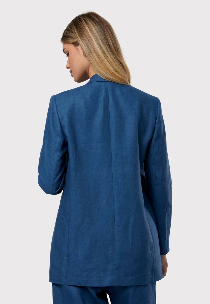 Cassie, the investment-worthy borage blue linen blazer. The epitome of summer sophistication. Minimalist styling accentuated by a single button fastening and an oversized, slightly boxy silhouette. Pair it effortlessly with a simple tee and the coordinating Vanessa pant, finished with trainers for a chic and contemporary ensemble.