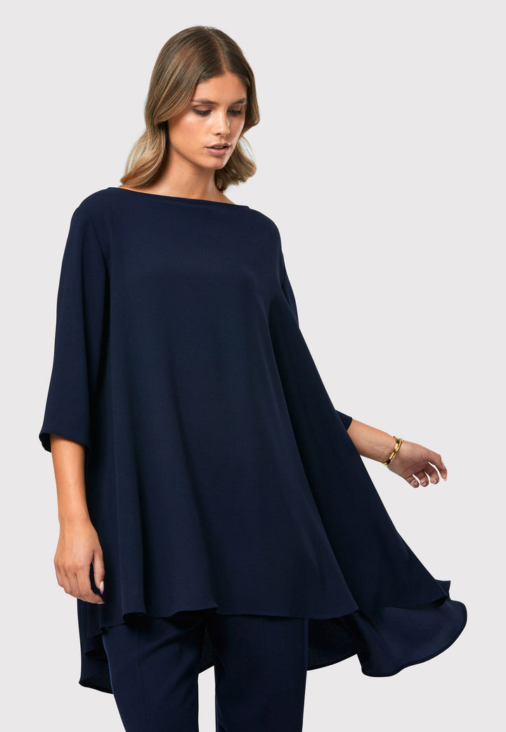  This stunning top features three - quarter sleeve and a slash neckline. The dropped hem design creates an intriguing silhouette, revealing a subtle peak of satin for a touch of allure.