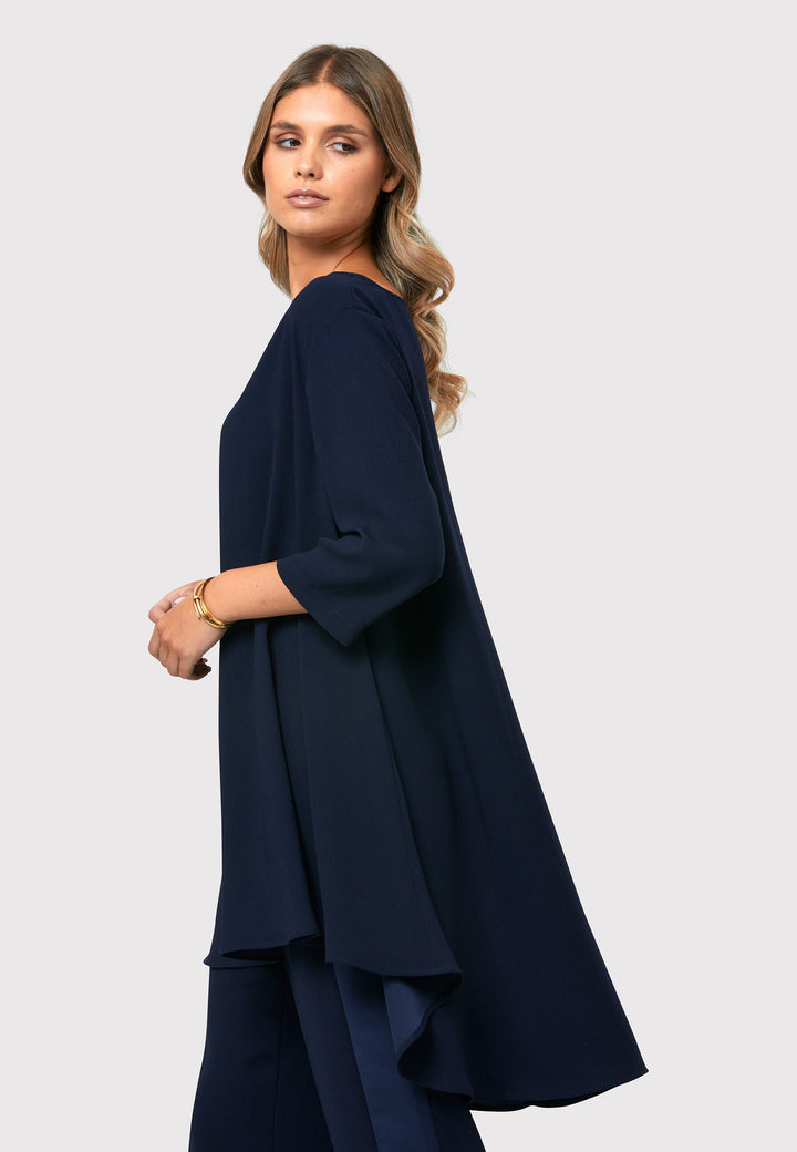  This stunning top features three - quarter sleeve and a slash neckline. The dropped hem design creates an intriguing silhouette, revealing a subtle peak of satin for a touch of allure.
