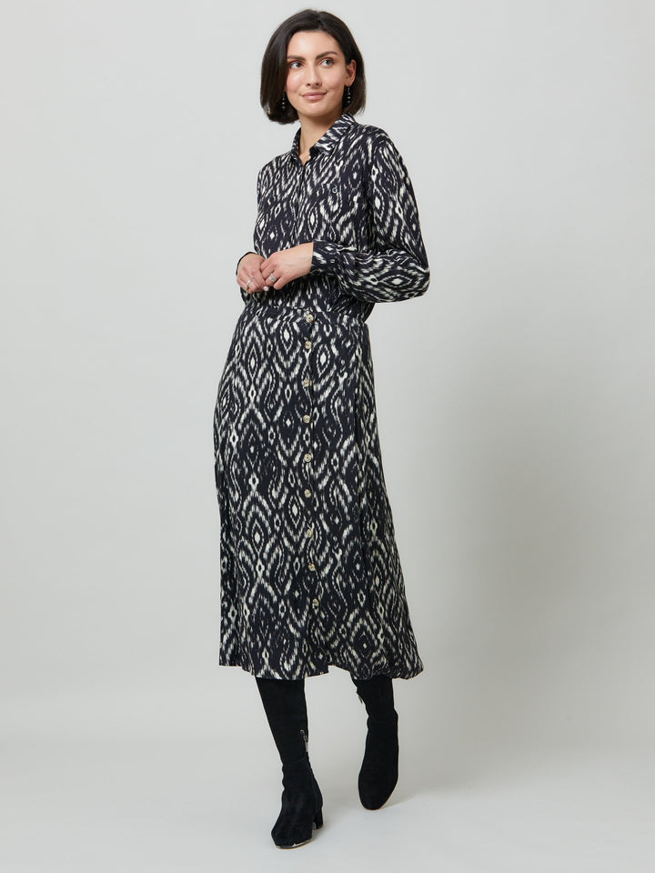 Sonia, a feminine take on the shirt dress. crafted in a fluid black and cream ikat printed viscose. A softly pleated skirt that falls to mid-calf. Wear to work, to the theatre, or out for cocktails with the girls. A simple yet feminine silhouette.