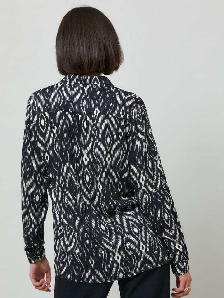 Ella, a classic utilitarian shirt crafted in a fluid black and cream ikat printed viscose. This must-have shirt features patch pockets, back yoke & center back box pleat. an easy-fit shirt to elevate your everyday. Helen's tip - style with the jill black pant for a sense of put-together ease.