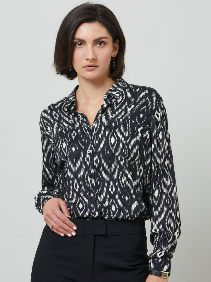 Ella, a classic utilitarian shirt crafted in a fluid black and cream ikat printed viscose. This must-have shirt features patch pockets, back yoke & center back box pleat. an easy-fit shirt to elevate your everyday. Helen's tip - style with the jill black pant for a sense of put-together ease.