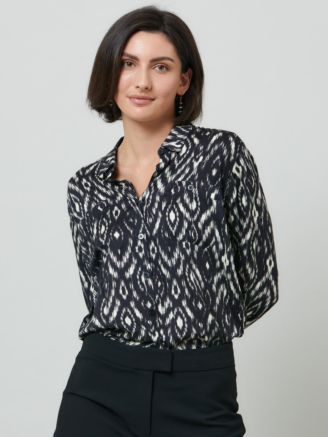 Ella, a classic utilitarian shirt crafted in a fluid black and cream ikat printed viscose. This must-have shirt features patch pockets, back yoke & center back box pleat. an easy-fit shirt to elevate your everyday. Helen's tip - style with the jill black pant for a sense of put-together ease.