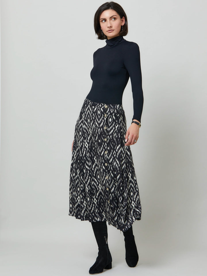 Meet saddie, the essential transeasonal skirt. Crafted in a fluid black and cream ikat printed viscose.. Off centered button through a-line silhouette with an elasticated back waist band. Relaxed elegance for everyday life. Style with our black timeless tops or dress it down with the khloe oatmeal sweatshirt.
