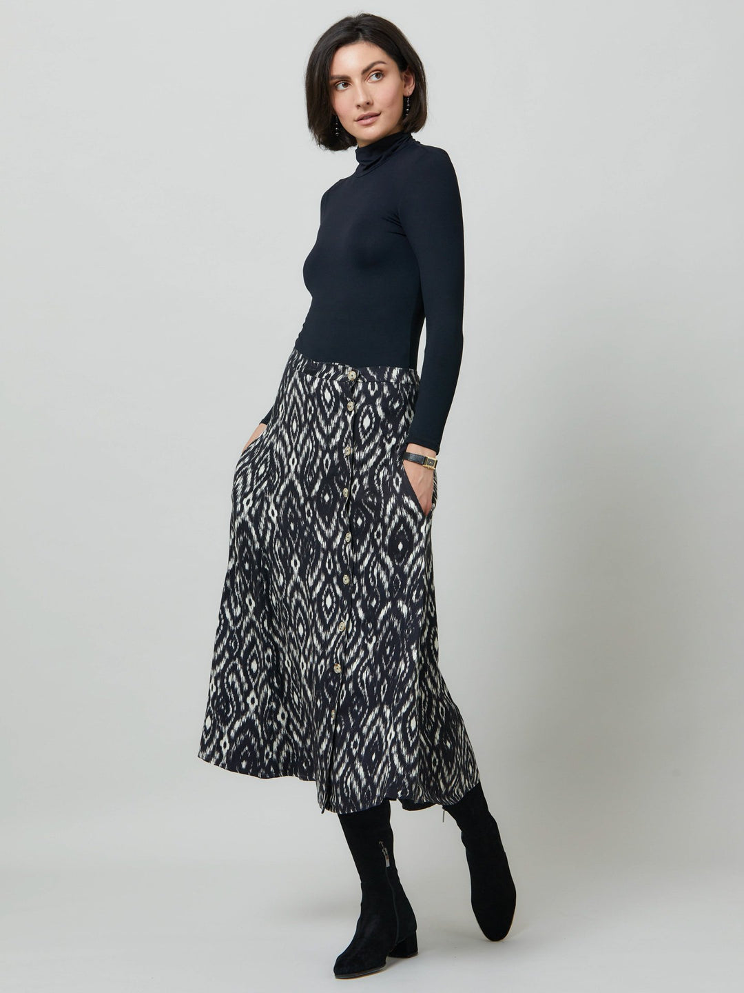 Meet saddie, the essential transeasonal skirt. Crafted in a fluid black and cream ikat printed viscose.. Off centered button through a-line silhouette with an elasticated back waist band. Relaxed elegance for everyday life. Style with our black timeless tops or dress it down with the khloe oatmeal sweatshirt.