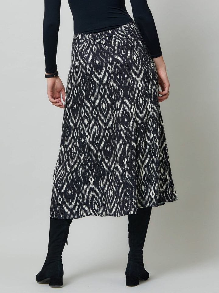 Meet saddie, the essential transeasonal skirt. Crafted in a fluid black and cream ikat printed viscose.. Off centered button through a-line silhouette with an elasticated back waist band. Relaxed elegance for everyday life. Style with our black timeless tops or dress it down with the khloe oatmeal sweatshirt.