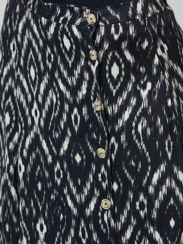 Meet saddie, the essential transeasonal skirt. Crafted in a fluid black and cream ikat printed viscose.. Off centered button through a-line silhouette with an elasticated back waist band. Relaxed elegance for everyday life. Style with our black timeless tops or dress it down with the khloe oatmeal sweatshirt.