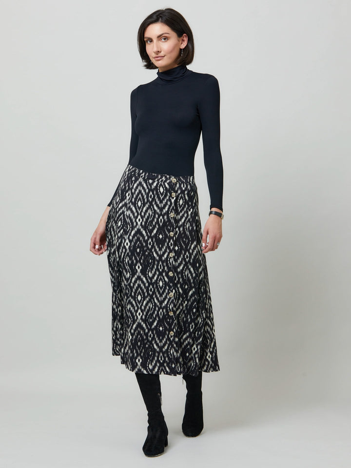 Meet saddie, the essential transeasonal skirt. Crafted in a fluid black and cream ikat printed viscose.. Off centered button through a-line silhouette with an elasticated back waist band. Relaxed elegance for everyday life. Style with our black timeless tops or dress it down with the khloe oatmeal sweatshirt.