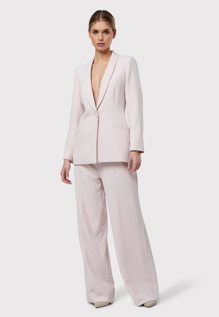 Meet the Darcie Soft Pink Jacket, a chic choice for minimalists. This tuxedo-style jacket boasts a seamless shawl collar, sleek welt pockets, and a flattering semi-fitted silhouette with a single-button closure. Crafted from our signature fabric blend, it offers comfort with a hint of stretch. Pair it with the matching Naomi Soft Pink Tailored Trouser for a complete, polished look.