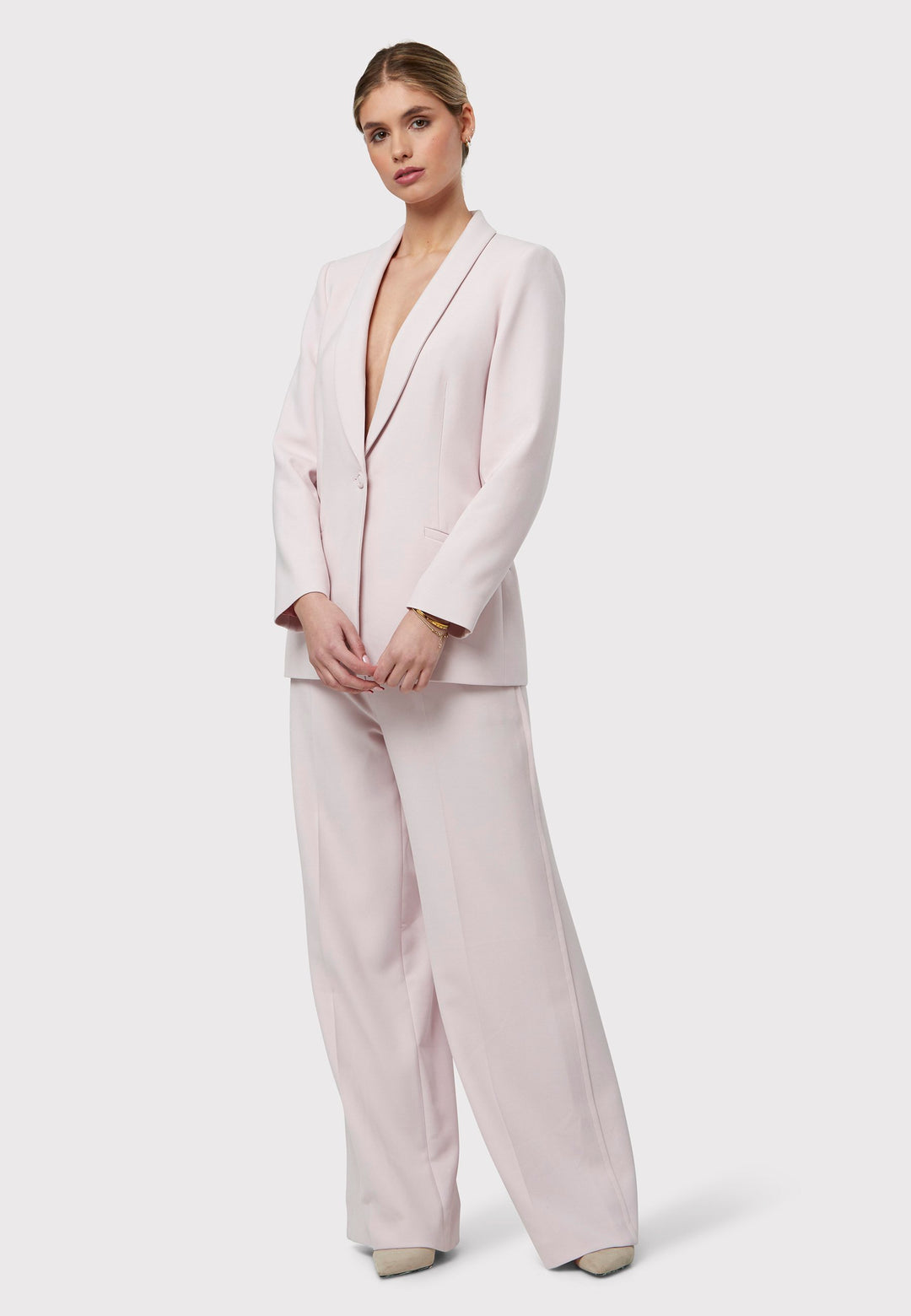 Meet the Darcie Soft Pink Jacket, a chic choice for minimalists. This tuxedo-style jacket boasts a seamless shawl collar, sleek welt pockets, and a flattering semi-fitted silhouette with a single-button closure. Crafted from our signature fabric blend, it offers comfort with a hint of stretch. Pair it with the matching Naomi Soft Pink Tailored Trouser for a complete, polished look.