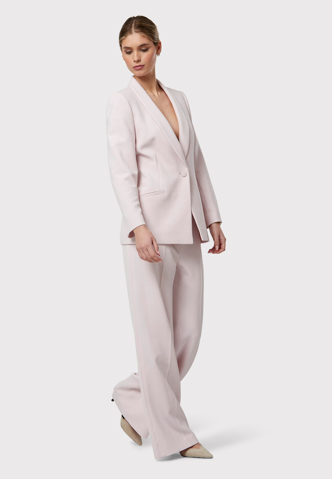 Meet the Darcie Soft Pink Jacket, a chic choice for minimalists. This tuxedo-style jacket boasts a seamless shawl collar, sleek welt pockets, and a flattering semi-fitted silhouette with a single-button closure. Crafted from our signature fabric blend, it offers comfort with a hint of stretch. Pair it with the matching Naomi Soft Pink Tailored Trouser for a complete, polished look.