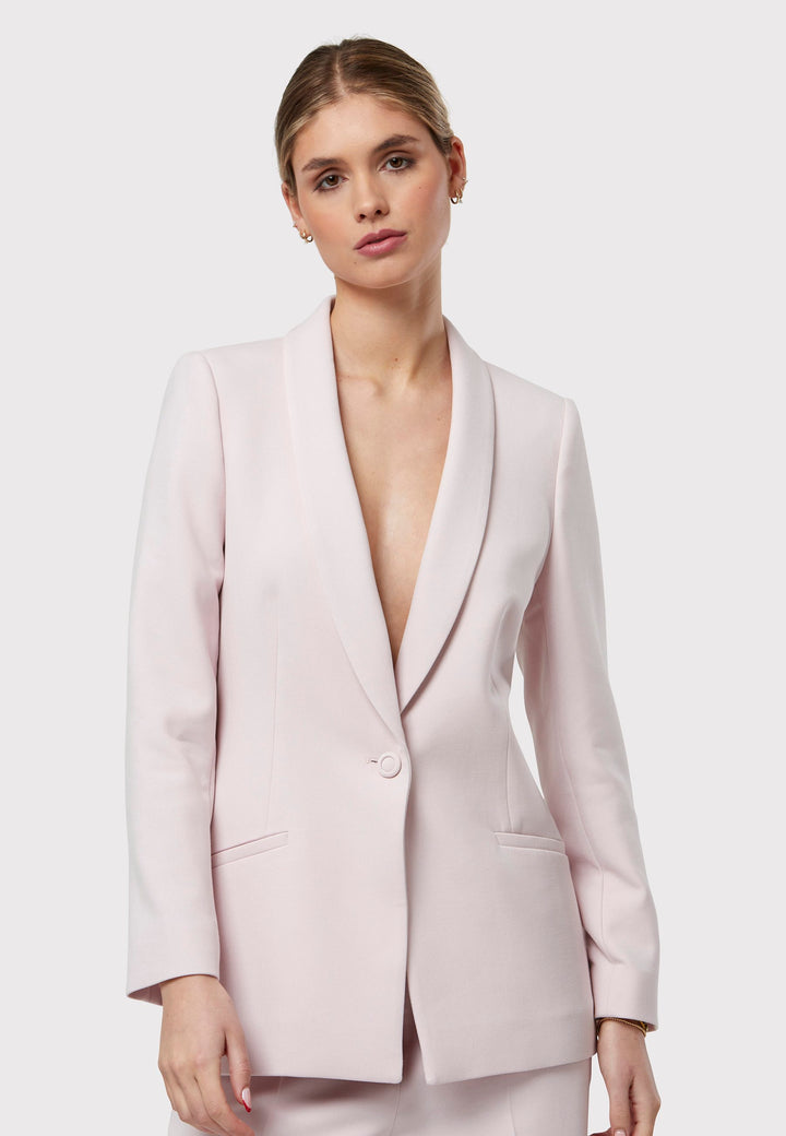 Meet the Darcie Soft Pink Jacket, a chic choice for minimalists. This tuxedo-style jacket boasts a seamless shawl collar, sleek welt pockets, and a flattering semi-fitted silhouette with a single-button closure. Crafted from our signature fabric blend, it offers comfort with a hint of stretch. Pair it with the matching Naomi Soft Pink Tailored Trouser for a complete, polished look.