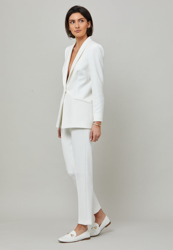 Darcie, a minimalist wardrobe must-have. This investment-worthy tailored tux jacket is engineered with a classic shawl collar and simple jeet pockets. Cut to a semi fitted silhouette with a single button closure. Fabricated in our signature double crepe with a hint of stretch in iconic white. The perfect balance between classic & elegance. Pair with a simple tee or elevate the look with the co-ordinating jill pant.
