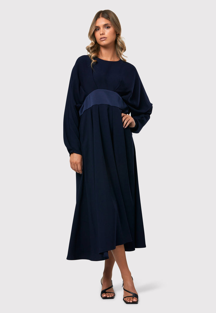 Drew Midnight Navy Dress, an ankle-grazing ensemble crafted from luxurious satin back crepe. This dress exudes elegance with its sophisticated design. The satin empire line panel beautifully accentuates the waist, creating a flattering silhouette. The dress features dropped sleeves, adding a touch of modernity to the overall look. 