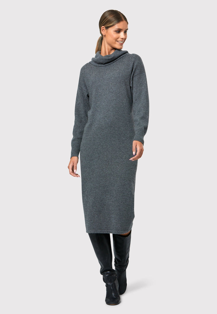Have you met the Elora Camel Cashmere Dress? A chic and versatile addition to your wardrobe. This midi-length dress features a loose and drapey polo neck, exuding effortless elegance. With full-length sleeves and a tight ribbed cuff, it offers a stylish and comfortable fit. Crafted from luxurious cashmere, this dress combines sophistication and comfort.