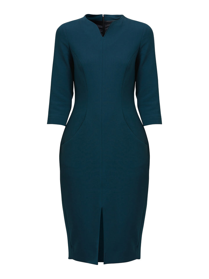 Elevate your professional attire with the Emma Dress, a refined choice that enhances your workwear options. This dress boasts a flattering body-skimming silhouette. The softly curved slash neck adds a touch of sophistication, while the front seam detail gracefully extends into an open slit above the knee, creating an alluring effect. Crafted with care in a sumptuous jade tone, the Emma Dress is a testament to impeccable style, perfect for making a lasting impression.