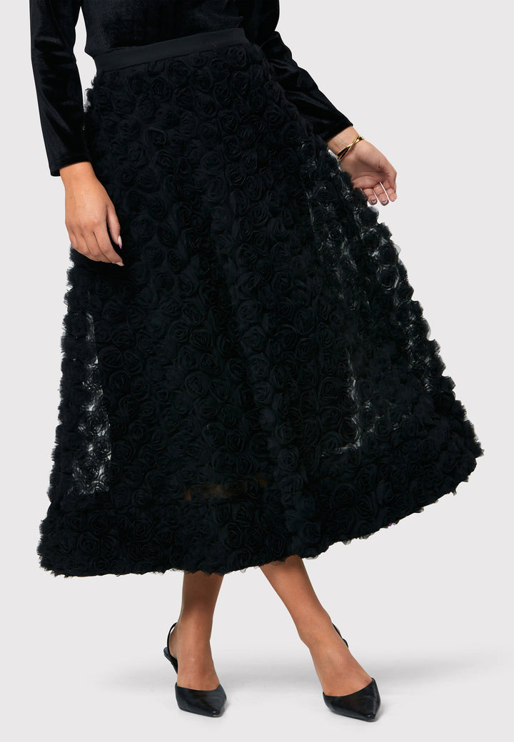 Introducing the Felicity Black Rose Skirt, a chic mid-calf length skirt inspired by 1950s fashion. Made from textured rose georgette fabric. An A-line silhouette reminiscent of the iconic 50s style. This statement piece features a convenient side seam zip, ensuring easy and comfortable wearing. Perfect for special occasions, it adds an elegant touch to your ensemble, making you the center of attention with its captivating beauty.