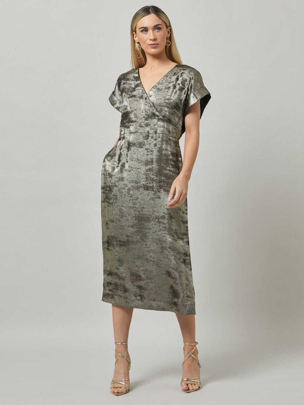 Fleur, play the elegance card in this shimmering metallic dress. An easy-fitting silhouette with a v-neckline, falls to the mid-calf and features side slit, pockets, and an elegant key-hole back neck detail.