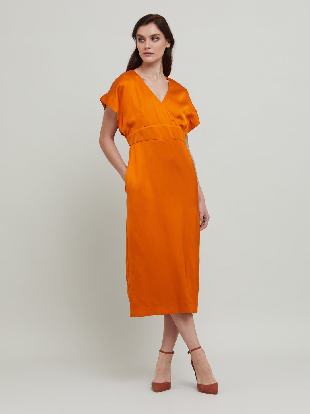Classic occasion wear, modernized. Meet the Fleur Dress in luxurious burnished rust satin viscose. An easy-fitting silhouette with a v-neckline, falls to the mid-calf and features side slit, pockets, and an elegant key-hole back neck detail.  Attending a summer wedding? Mother of the bride? Heading to the races? This is the dress for you. Designed in Ireland by Helen McAlinden. Made in Europe. Free shipping to the EU & UK.