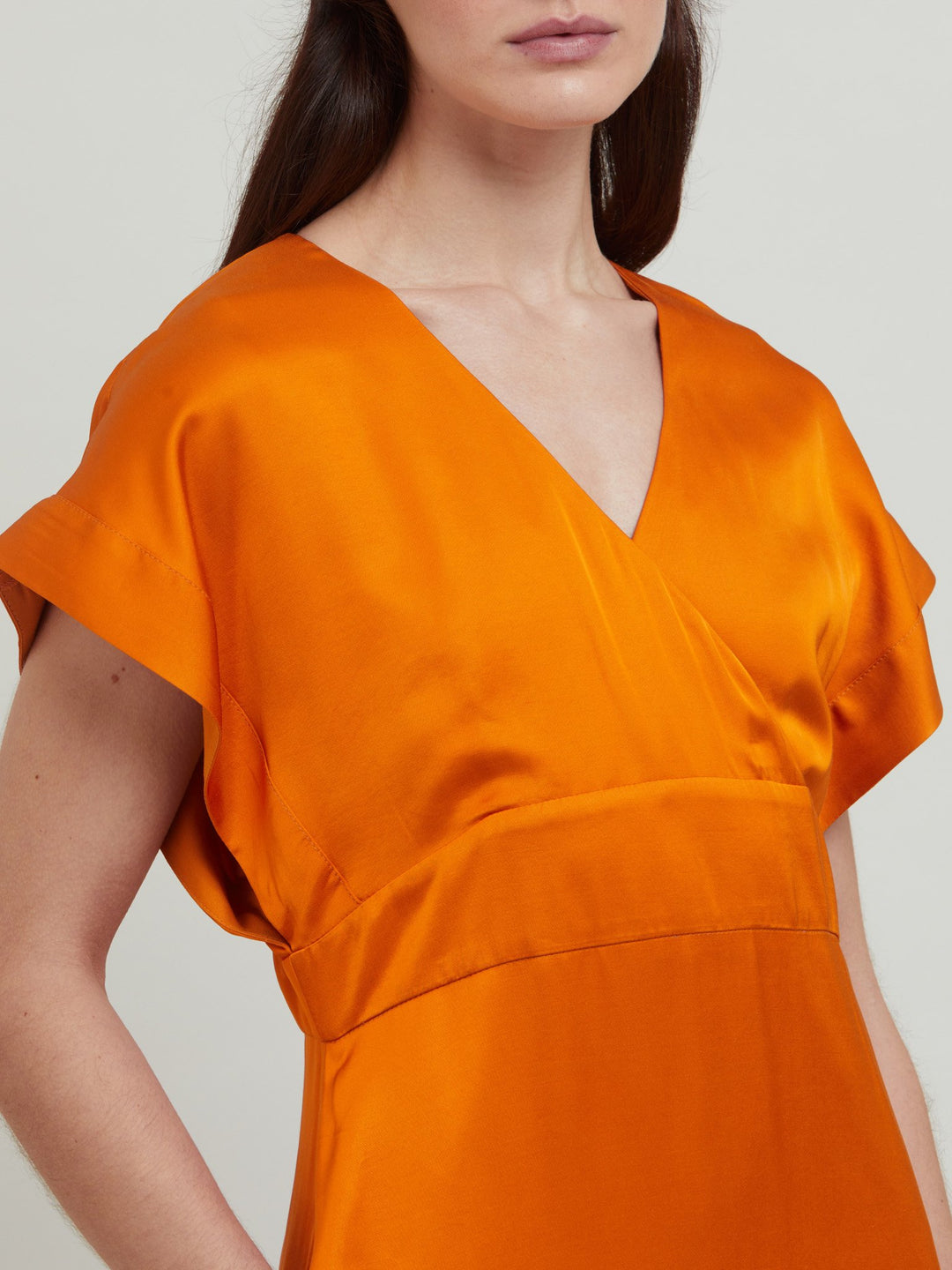 Classic occasion wear, modernized. Meet the Fleur Dress in luxurious burnished rust satin viscose. An easy-fitting silhouette with a v-neckline, falls to the mid-calf and features side slit, pockets, and an elegant key-hole back neck detail.  Attending a summer wedding? Mother of the bride? Heading to the races? This is the dress for you. Designed in Ireland by Helen McAlinden. Made in Europe. Free shipping to the EU & UK.