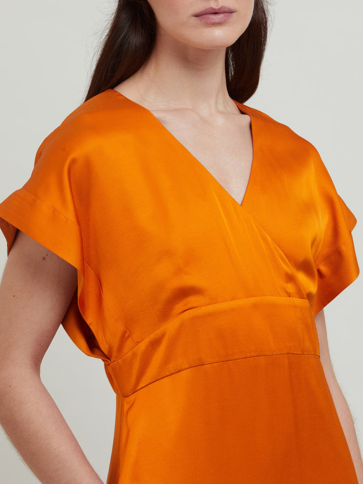 Classic occasion wear, modernized. Meet the Fleur Dress in luxurious burnished rust satin viscose. An easy-fitting silhouette with a v-neckline, falls to the mid-calf and features side slit, pockets, and an elegant key-hole back neck detail.  Attending a summer wedding? Mother of the bride? Heading to the races? This is the dress for you. Designed in Ireland by Helen McAlinden. Made in Europe. Free shipping to the EU & UK.