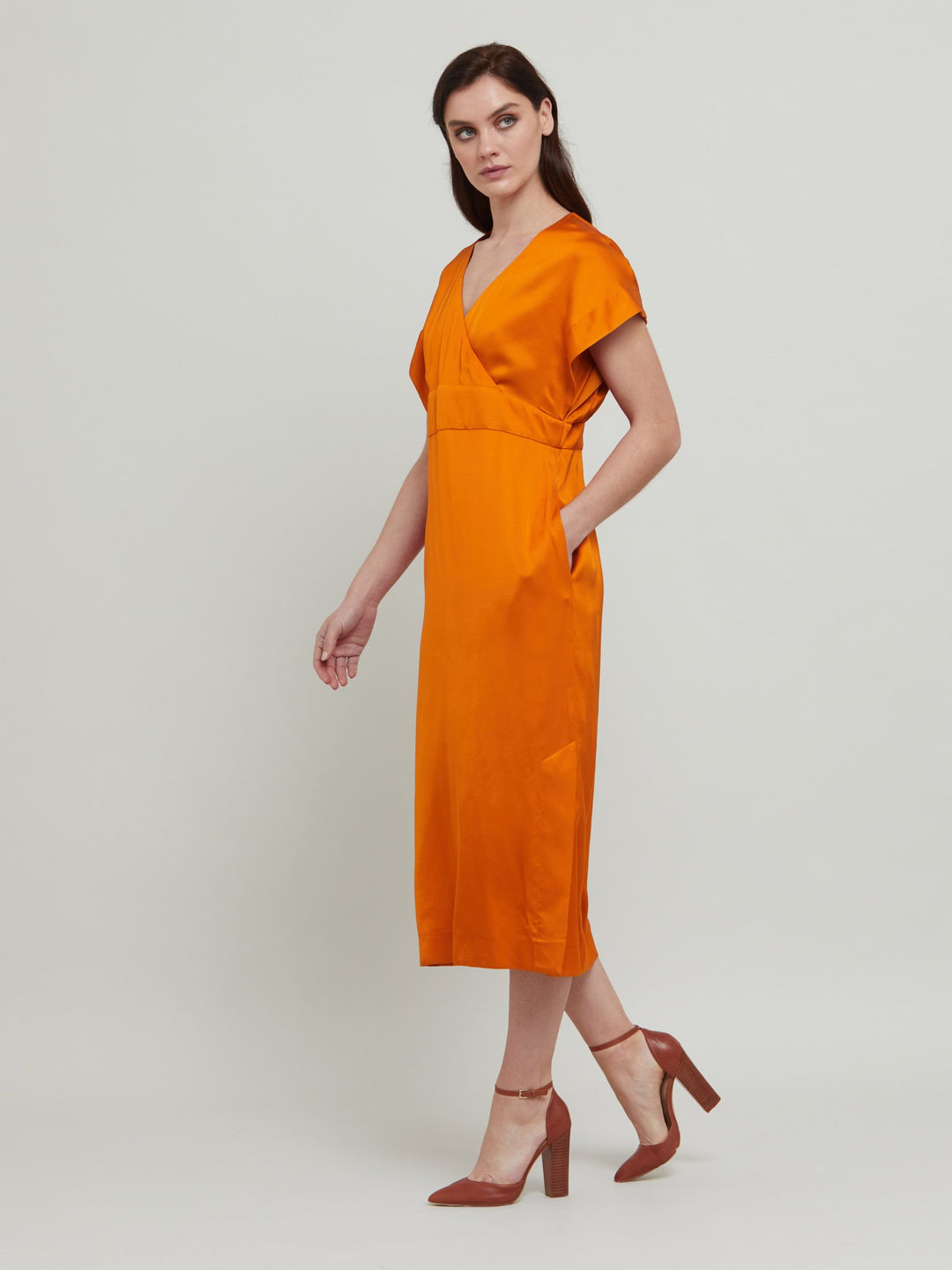 Classic occasion wear, modernized. Meet the Fleur Dress in luxurious burnished rust satin viscose. An easy-fitting silhouette with a v-neckline, falls to the mid-calf and features side slit, pockets, and an elegant key-hole back neck detail.  Attending a summer wedding? Mother of the bride? Heading to the races? This is the dress for you. Designed in Ireland by Helen McAlinden. Made in Europe. Free shipping to the EU & UK.