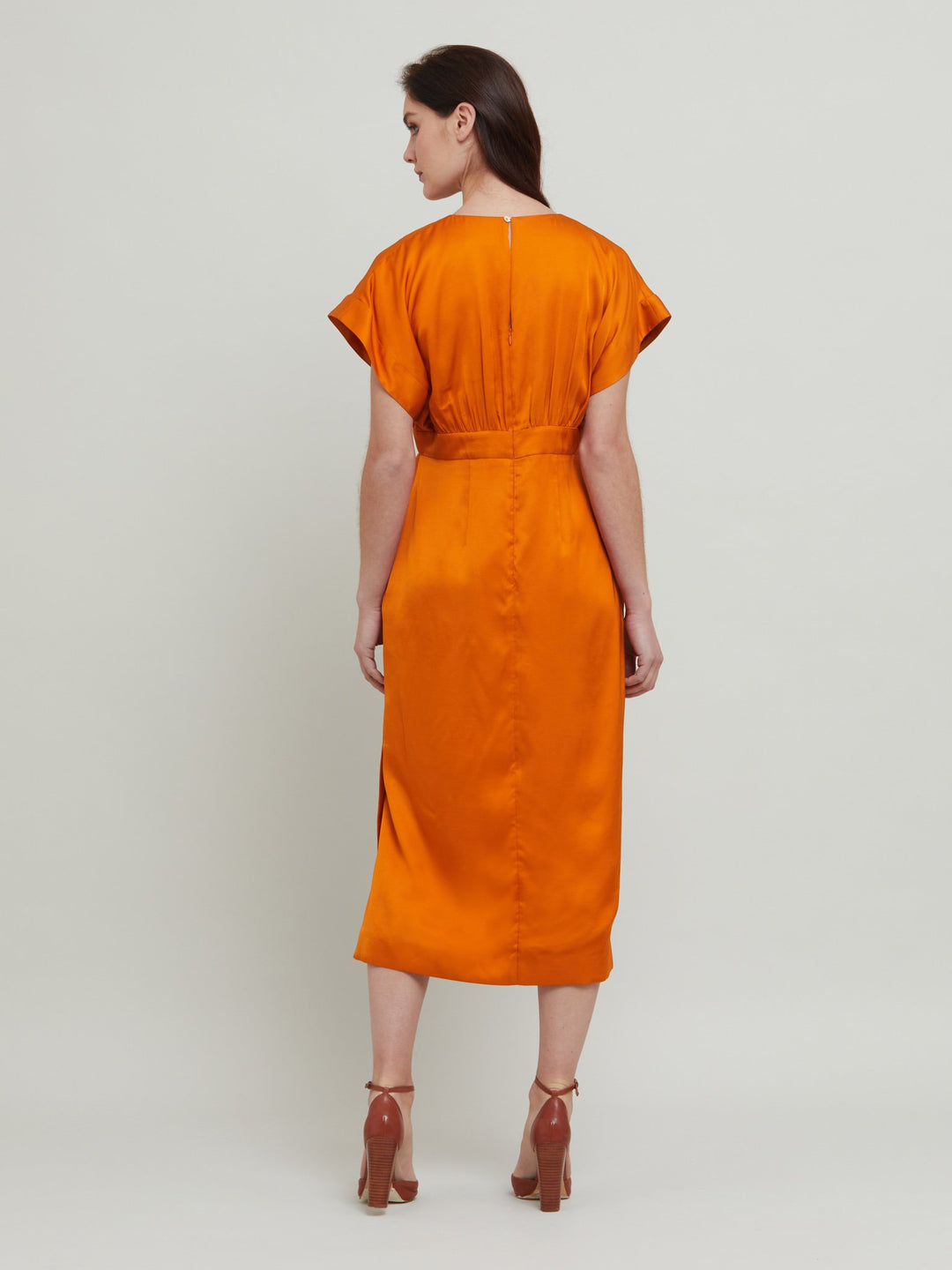 Classic occasion wear, modernized. Meet the Fleur Dress in luxurious burnished rust satin viscose. An easy-fitting silhouette with a v-neckline, falls to the mid-calf and features side slit, pockets, and an elegant key-hole back neck detail.  Attending a summer wedding? Mother of the bride? Heading to the races? This is the dress for you. Designed in Ireland by Helen McAlinden. Made in Europe. Free shipping to the EU & UK.