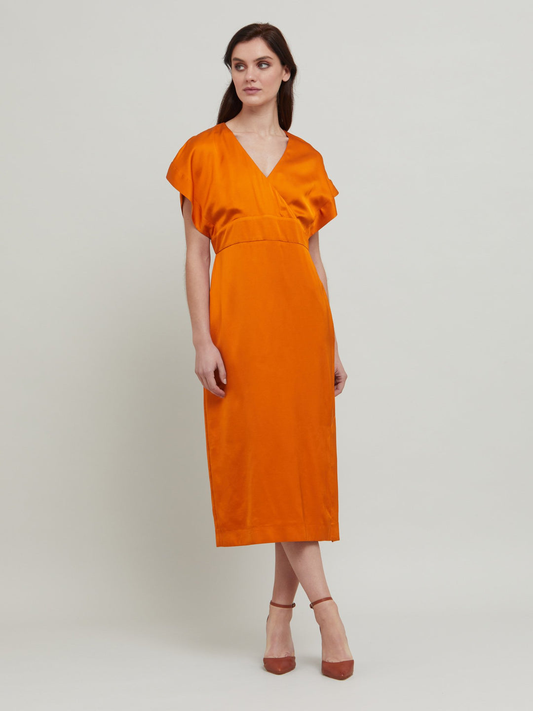 Classic occasion wear, modernized. Meet the Fleur Dress in luxurious burnished rust satin viscose. An easy-fitting silhouette with a v-neckline, falls to the mid-calf and features side slit, pockets, and an elegant key-hole back neck detail.  Attending a summer wedding? Mother of the bride? Heading to the races? This is the dress for you. Designed in Ireland by Helen McAlinden. Made in Europe. Free shipping to the EU & UK.