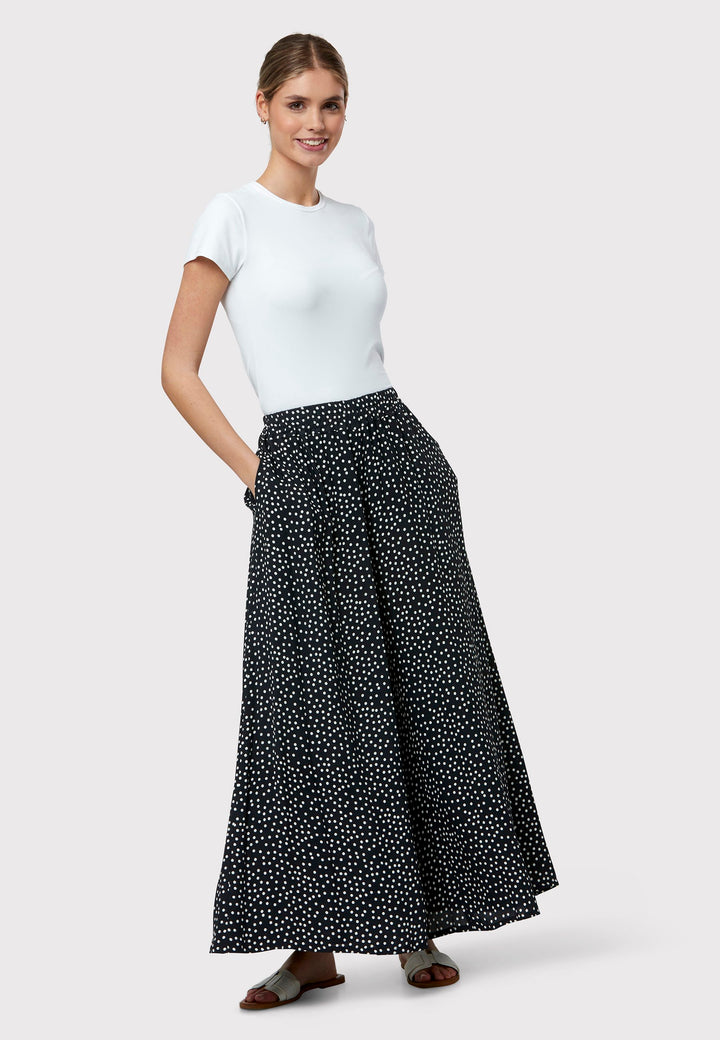 The Imogen Navy and White Polka Dot Trousers bring chic versatility to your wardrobe. With a drapey wide leg and crafted from our beloved sustainable viscose crepe, these trousers prioritize comfort with an elasticated gathered waistband. The timeless navy adorned with white polka dots adds a classic touch, elegantly falling to the ankle.