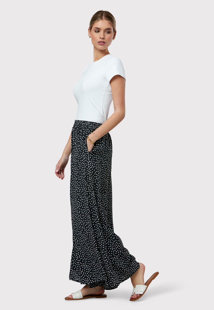 The Imogen Navy and White Polka Dot Trousers bring chic versatility to your wardrobe. With a drapey wide leg and crafted from our beloved sustainable viscose crepe, these trousers prioritize comfort with an elasticated gathered waistband. The timeless navy adorned with white polka dots adds a classic touch, elegantly falling to the ankle.