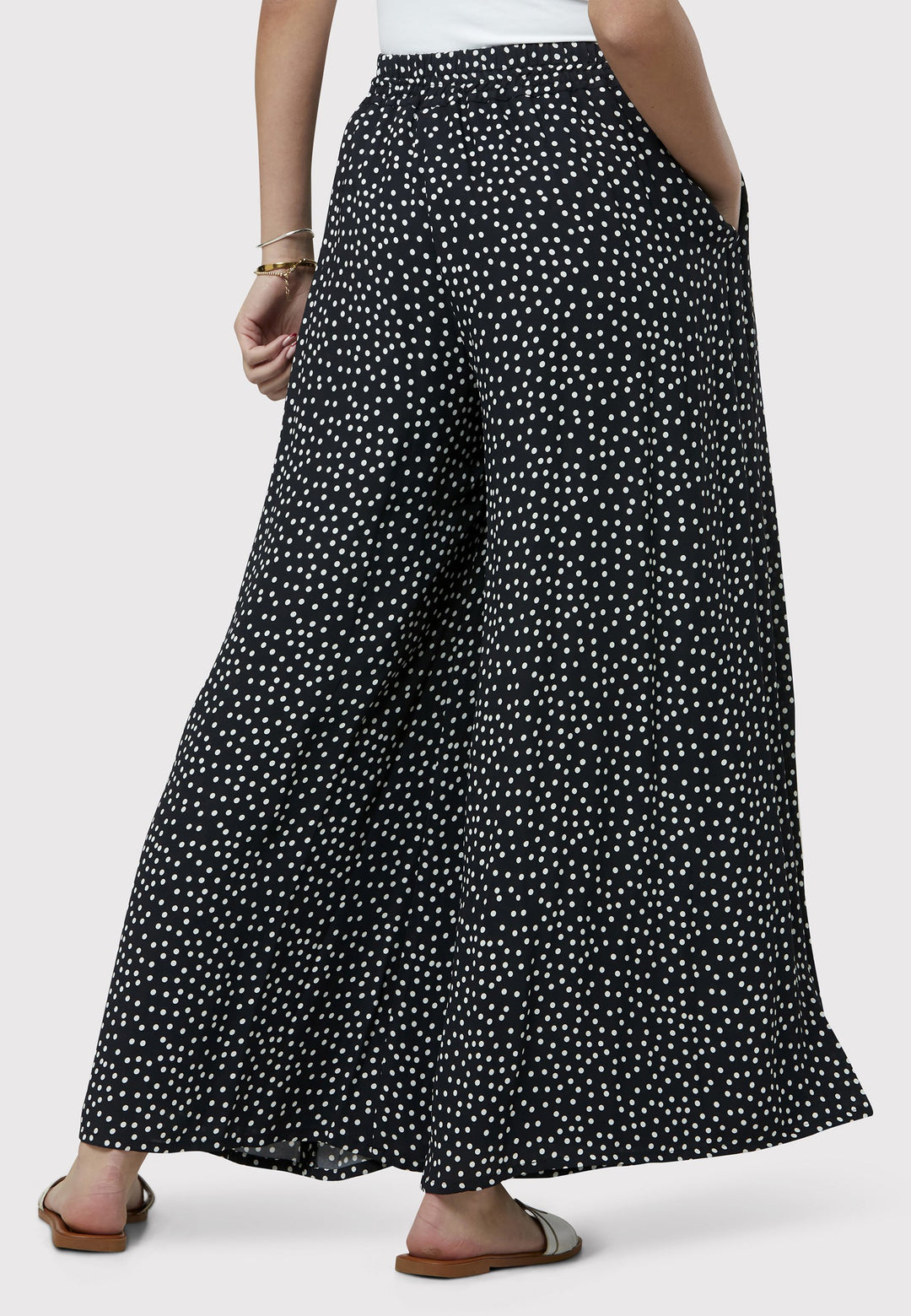 The Imogen Navy and White Polka Dot Trousers bring chic versatility to your wardrobe. With a drapey wide leg and crafted from our beloved sustainable viscose crepe, these trousers prioritize comfort with an elasticated gathered waistband. The timeless navy adorned with white polka dots adds a classic touch, elegantly falling to the ankle.