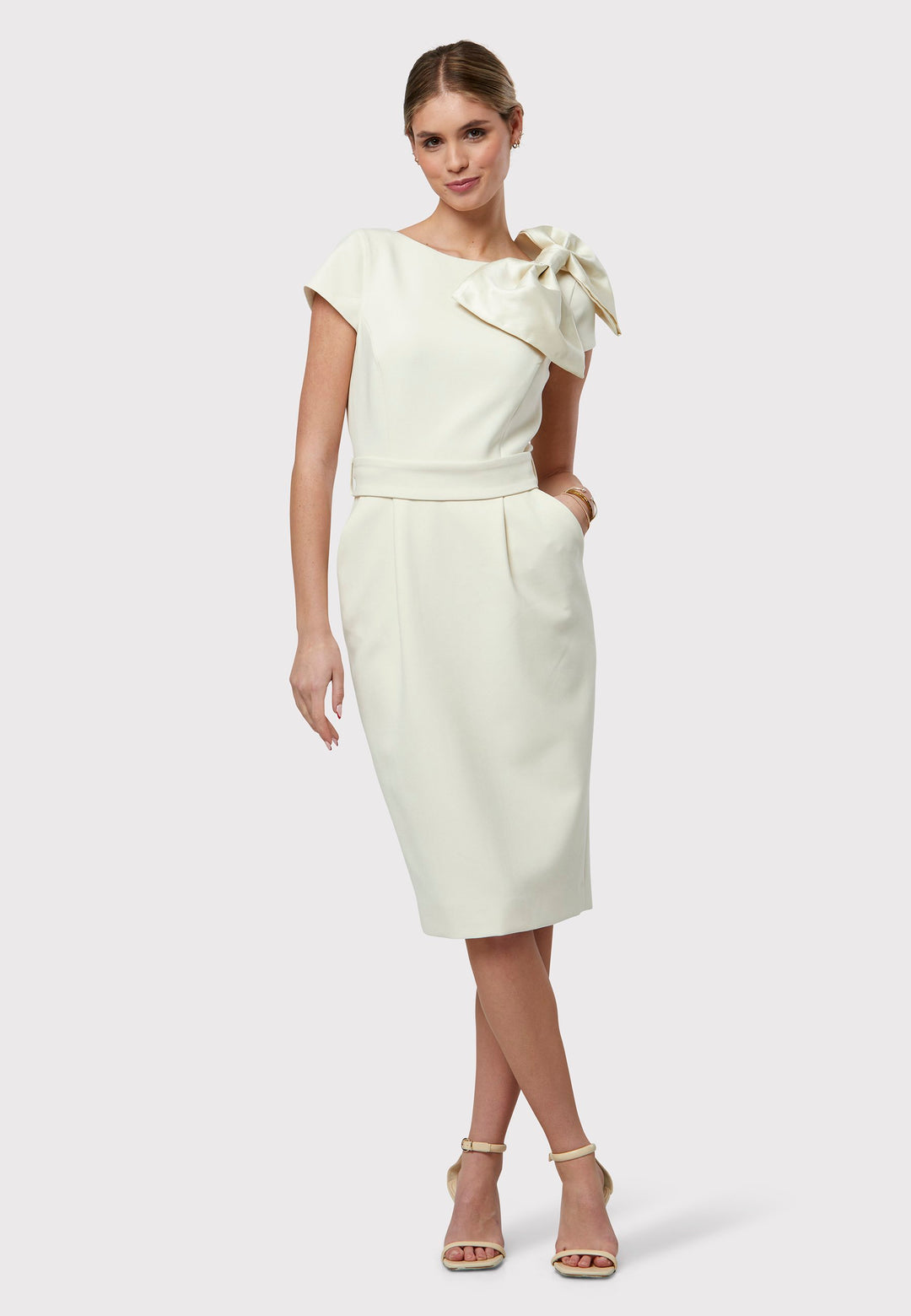 Jane exudes sophistication with its fitted design, featuring a chic slash neck and a flattering pencil skirt silhouette. Front tucks on the skirt ensure a tailored fit, while practical side seam pockets add functionality. Elevating its elegance, this dress includes a captivating detachable satin bow, introducing versatility to its design. Crafted from signature tricotine blended with a touch of elastane, it's perfect for weddings or races, ensuring you're ready for any occasion.