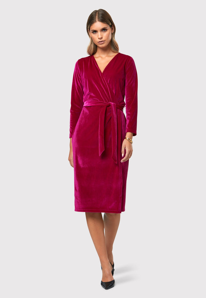 Introducing the Jordan Fuchsia Velvet Dress, a must-have addition to your winter wardrobe. This versatile dress combines luxurious stretch velvet a flattering v-neckline, offering a perfect blend of warmth, sophistication, and style. The faux wrap design creates a feminine silhouette that transitions seamlessly from desk to dinner, while the detachable belt allows you to customize your look to suit any occasion. 