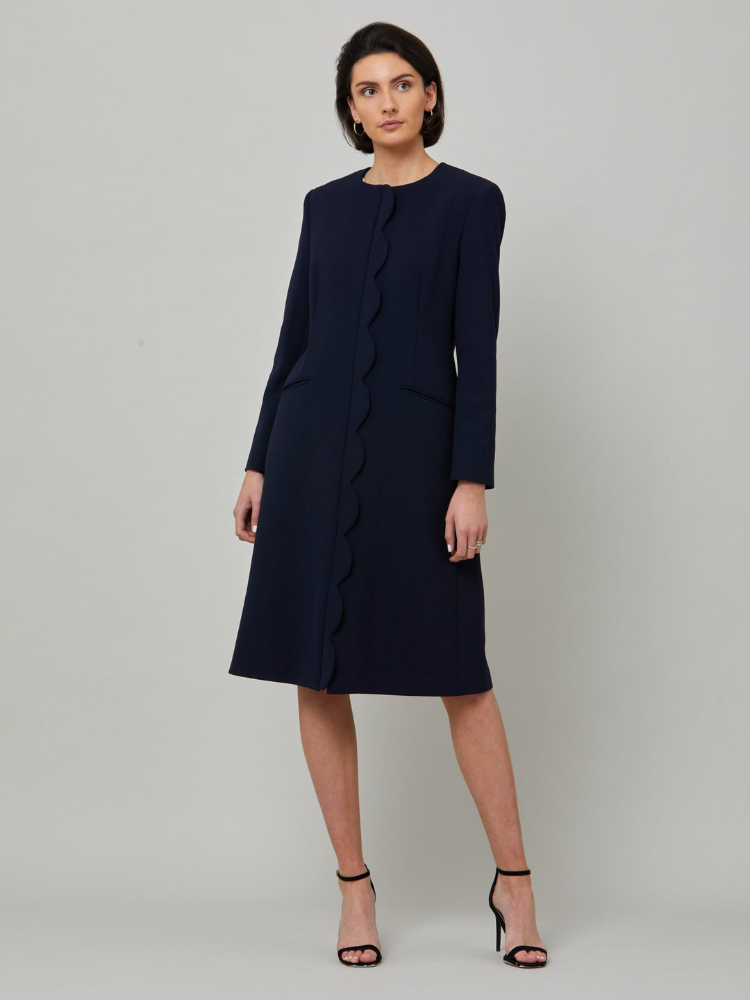 Meet Julia, the ultimate guest coat in classic navy. Body skimming silhouette, jewel neckline and elegant scallop front conceal a zip fastening. Think spring weddings or a day at the races.