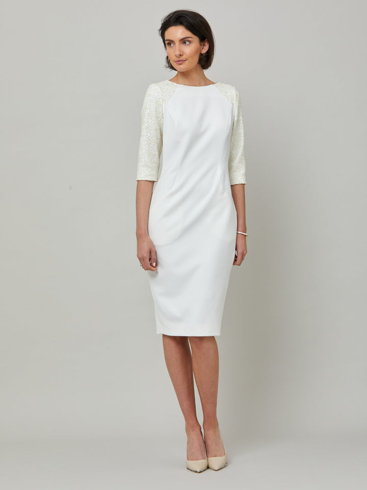 front picture of model Juliet, A form-flattering, body-skimming silhouette in iconic white. Features a 3/4 sleeve with lace overlay. The skirt falls to a demure finish below the knee. Attending a summer wedding? Mother of the bride? Heading to the races? This is the dress for you.