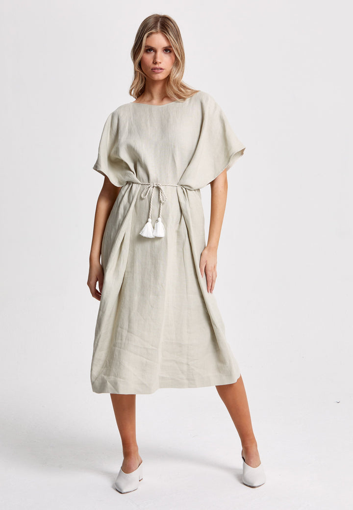 Kelani Oatmeal Kafan is designed with your summer vacation in mind. A loose-fitting pull-on dress with a V-neckline that embraces laid-back spirit. Cut from a sustainably sourced breathable Irish linen. A piece you can't travel without. This versatile style is designed to be worn in three different ways. Engineered with a channel and belt at the midriff that can be ruched and left loose, waisted and tied at the back or front. Ideal for a day at the beach followed by dinner at the pier.
