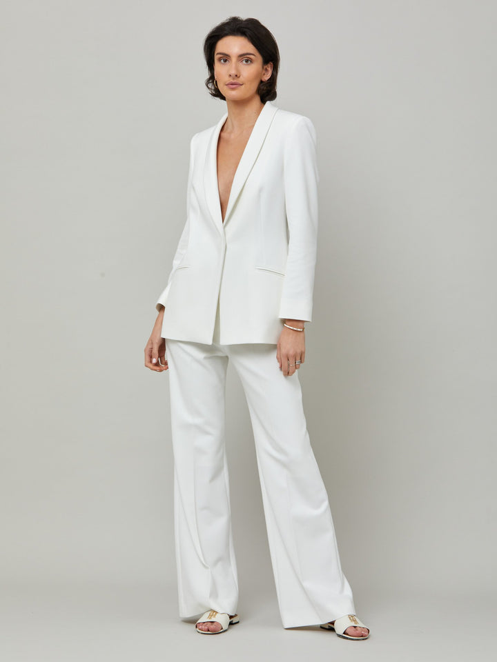 front picture of model wearing white suit with darcie blazer and kelly Kelly, an iconic white flare pant. Crafted in sustainable double crepe with a hint of stretch. Revisit the 70's for this season’s game-changing look. Flares are sophisticated, comfortable & leg-lengthening. Guaranteed to flatter the form & never far from fashion’s front line.