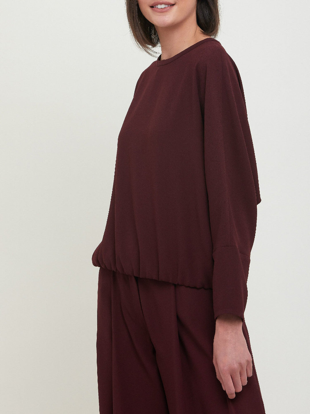 Lal, a crewneck relaxed fit sweatshirt. Crafted in a satin back crepe in rich burgundy. A sporty silhouette featuring an elasticated ribbed hem, dropped shoulder & full-length sleeve. Teams perfectly with matching Charlize pants. Clothes for how we live today! Loungewear re-defined. 