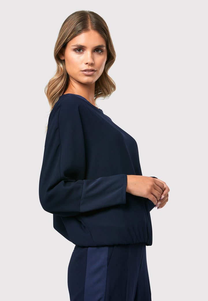 al Midnight Navy Top, a stylish and versatile addition to your wardrobe. Crafted from satin back crepe, it offers a luxurious feel and drapes beautifully. The dropped shoulder design, eleasticated hem and full-length sleeves 