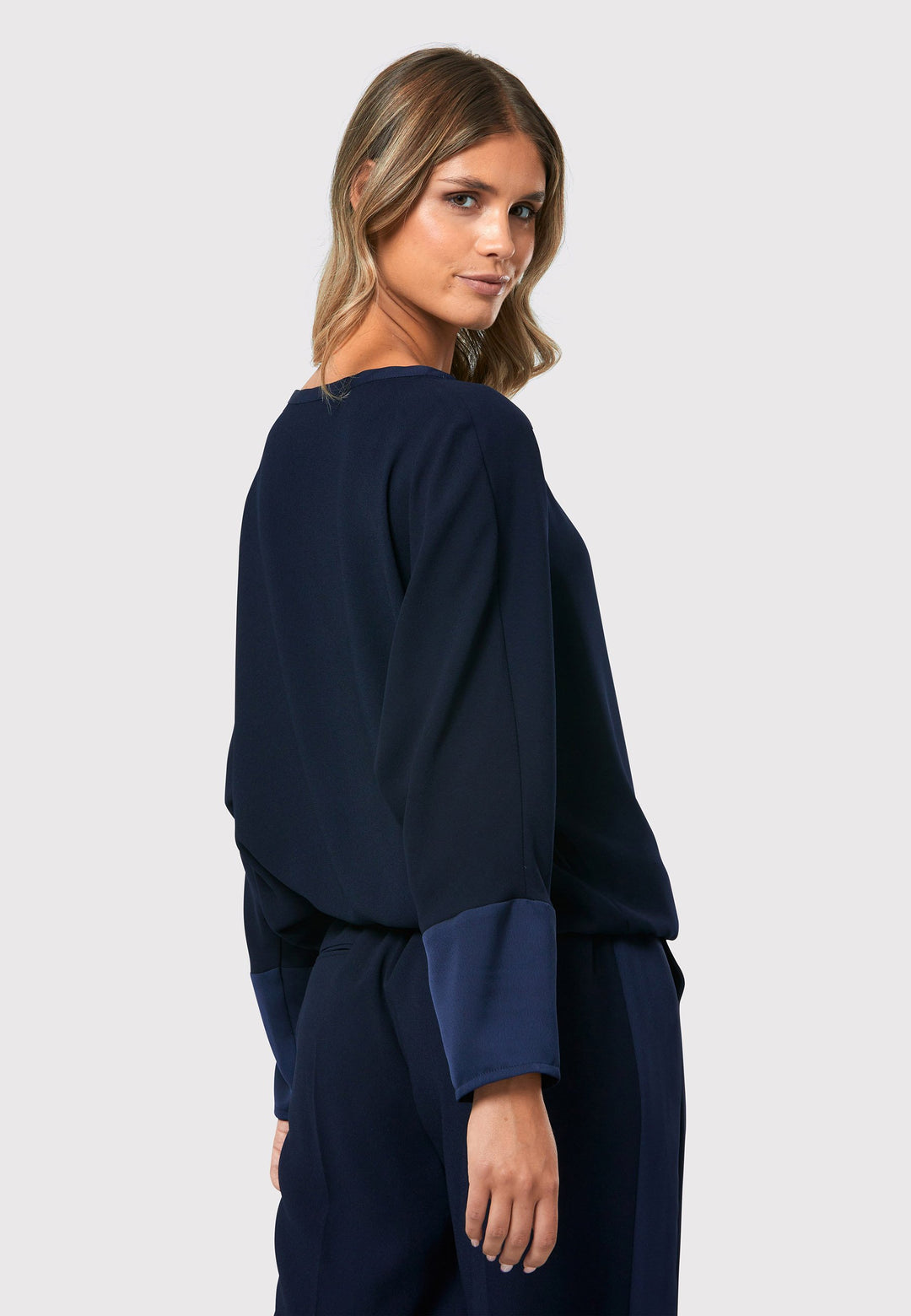 al Midnight Navy Top, a stylish and versatile addition to your wardrobe. Crafted from satin back crepe, it offers a luxurious feel and drapes beautifully. The dropped shoulder design, eleasticated hem and full-length sleeves 